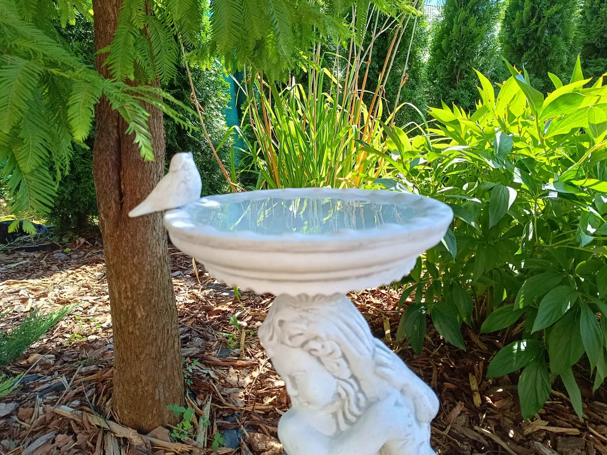 Bain d'oiseaux au design antique en forme de garçon tenant un poisson, fabriqué en pierre coulée